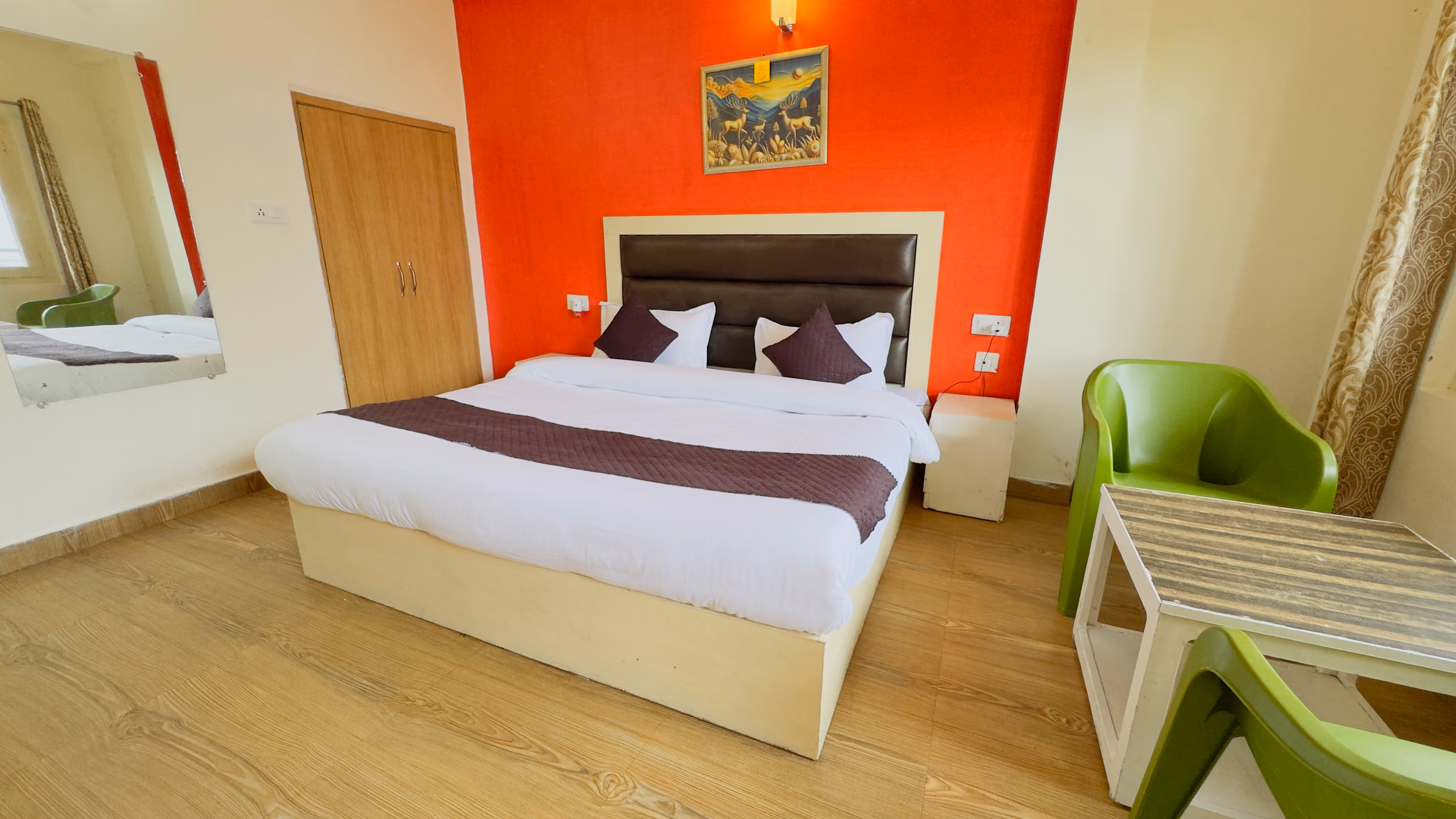 Deluxe room 207 with an orange feature wall behind the bed