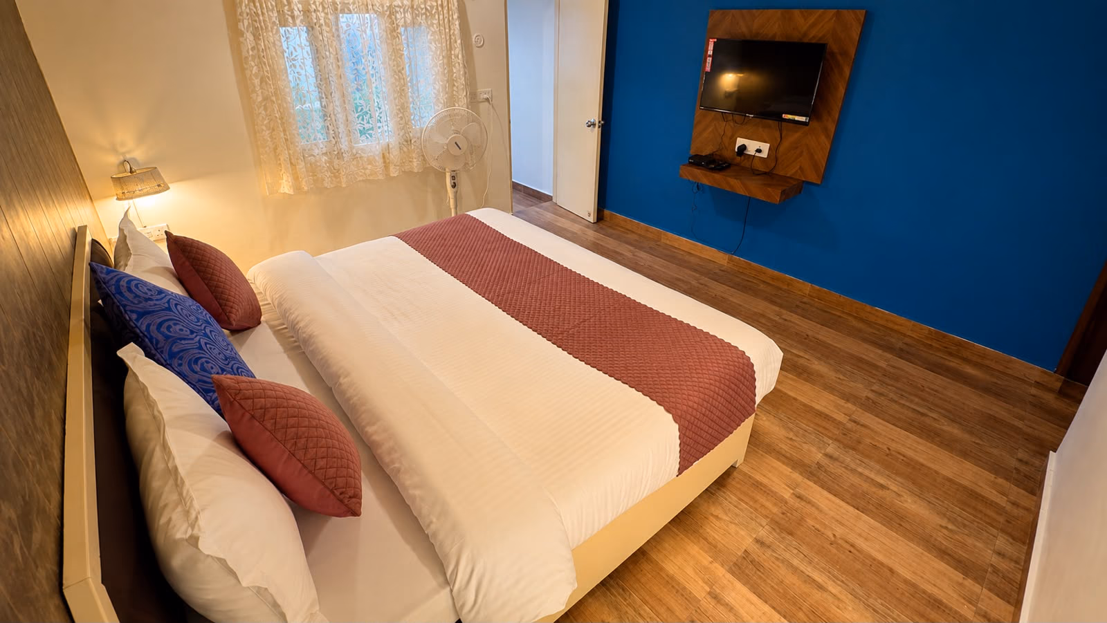 Luxury King room 102 with a blue feature wall and wall mounted television